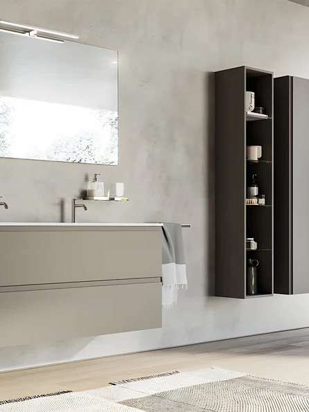 Petite salle de bains design avec meuble gris suspendu et colonne de rangement haute intégrée pour maximiser le rangement vertical
