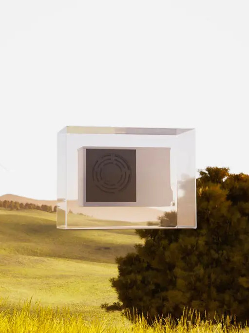 Compact outdoor air conditioning unit installed in a natural landscape with a wind turbine in the background