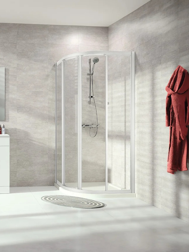 Cabine de douche quart de cercle avec portes coulissantes en verre transparent, installation en angle dans une salle de bains moderne avec receveur arrondi et profil chrome