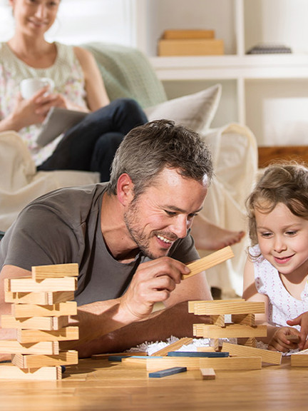Famille allongée sur un plancher chauffant profitant d’un confort thermique dans le salon