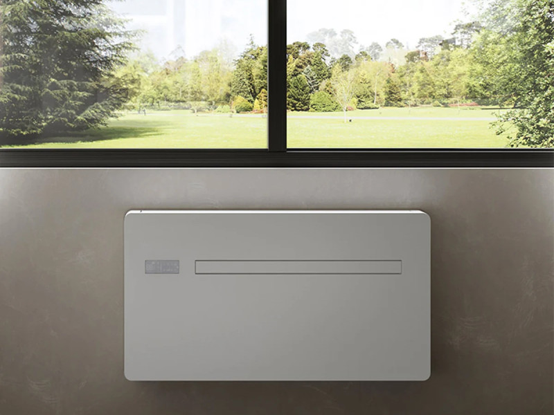 Console de climatisation réversible placée sous une fenêtre, offrant une diffusion discrète et homogène de l’air dans la pièce.