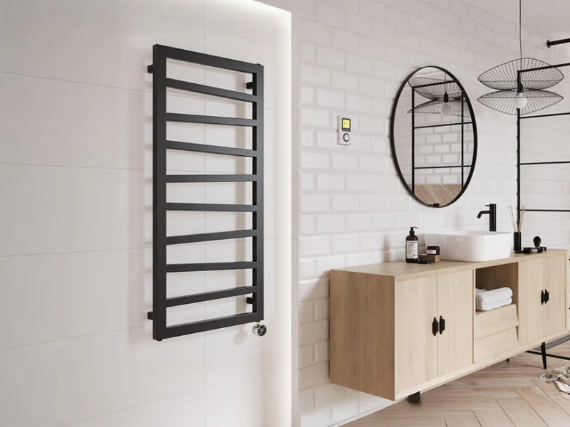 A matt black towel rail in a minimalist bathroom featuring white and light wood.